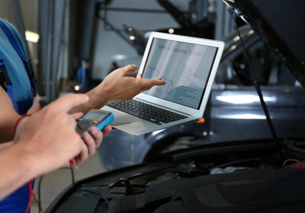 mechanics-with-laptop-doing-car-diagnostic-automobile-repair-shop-closeup mechanics-with-laptop-doing-car-diagnostic-automobile-repair-shop-closeup